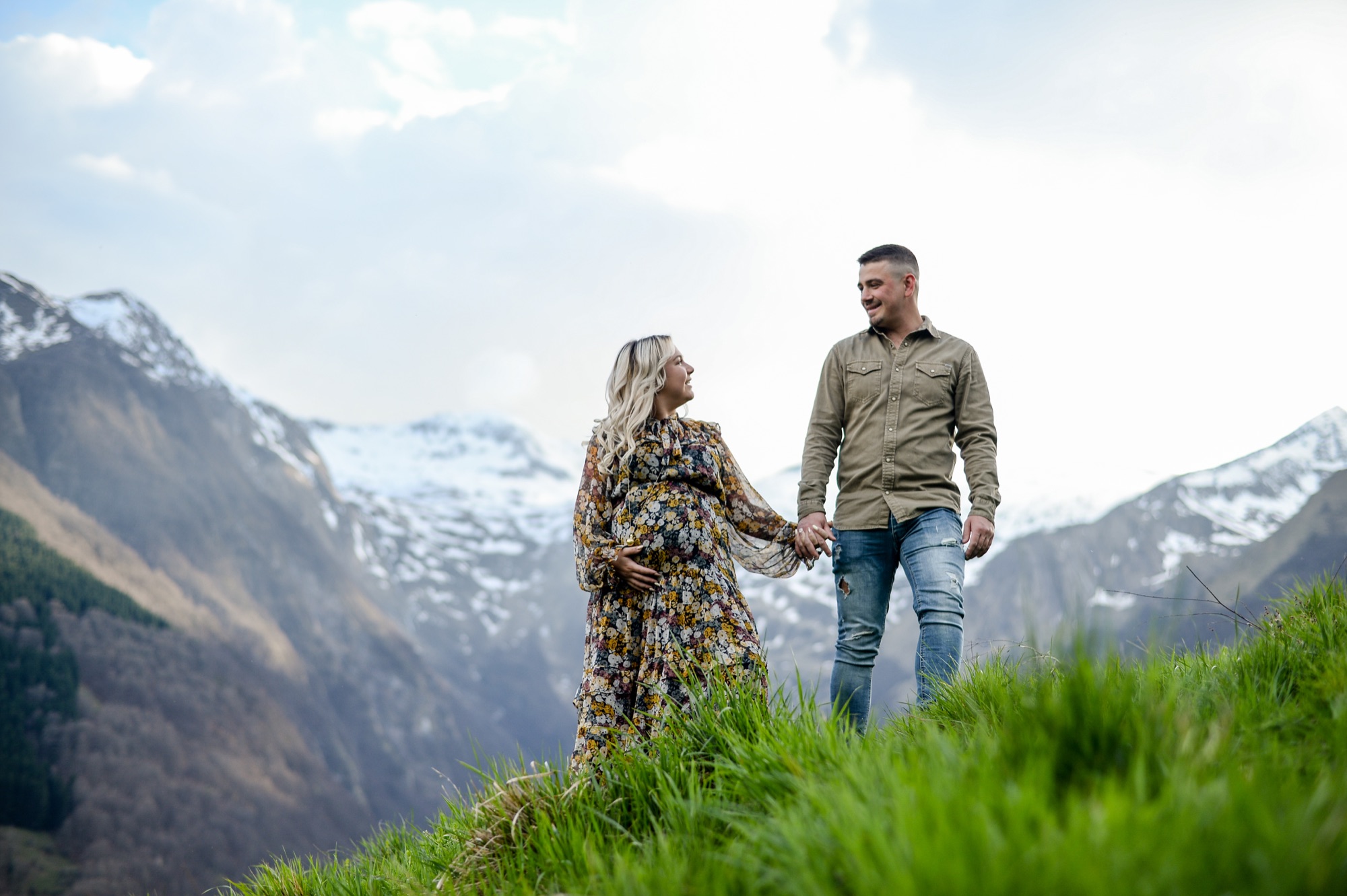 Femme enceinte et son compagnon face aux montagnes enneigées