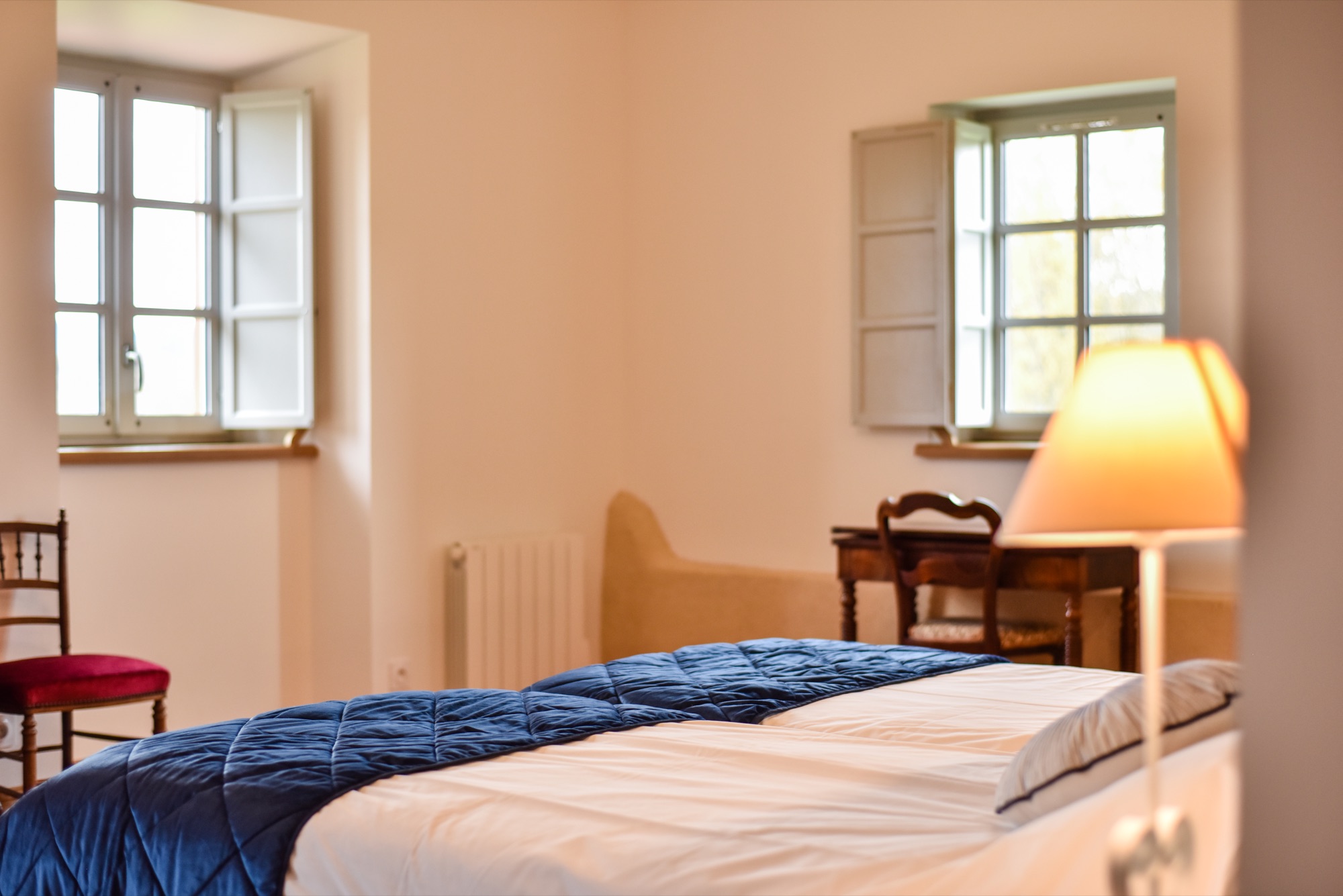 Chambre bleue et blanche avec fenêtres et lumière naturelle douce