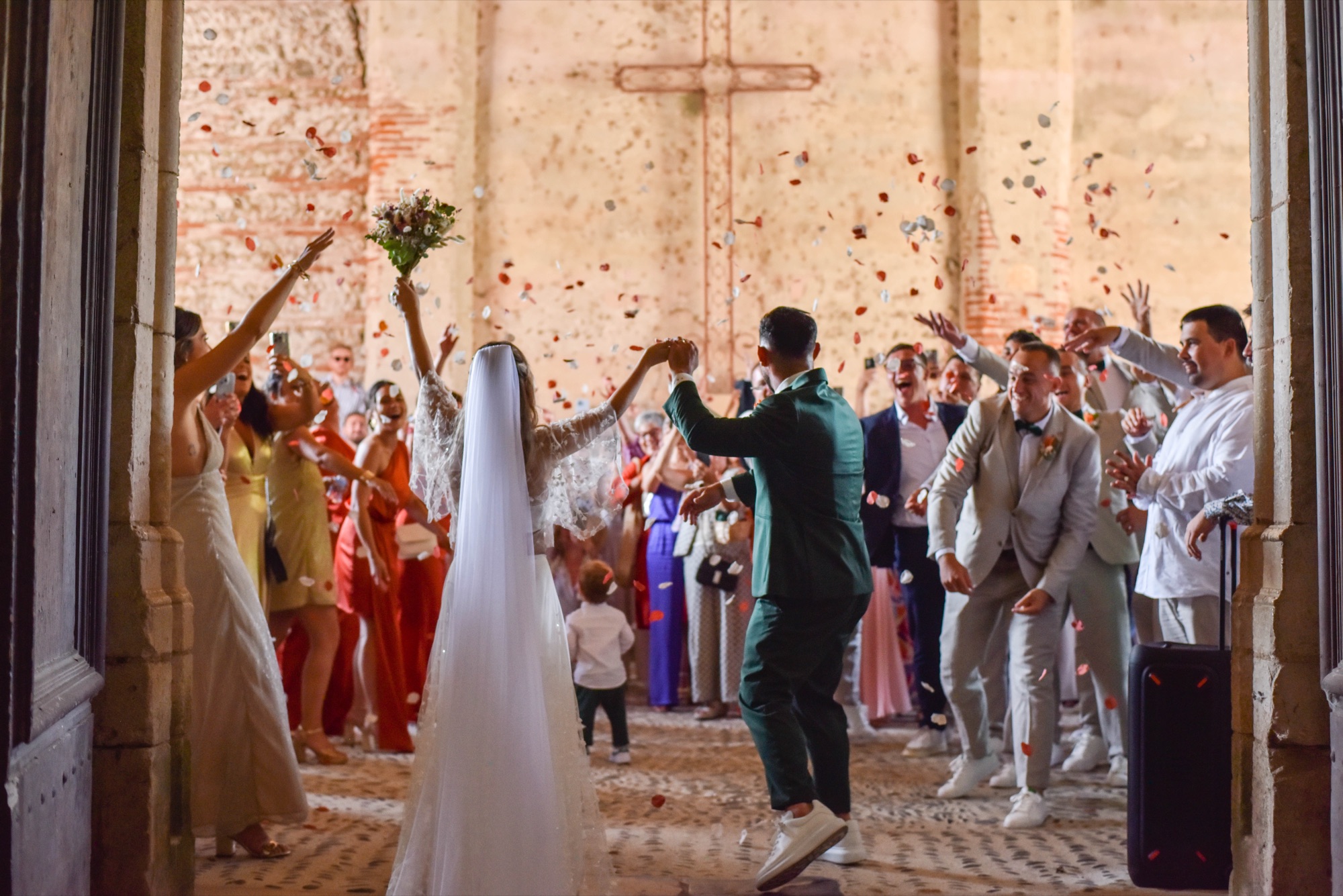 Sortie de cérémonie sous une pluie de confettis dans un cloître