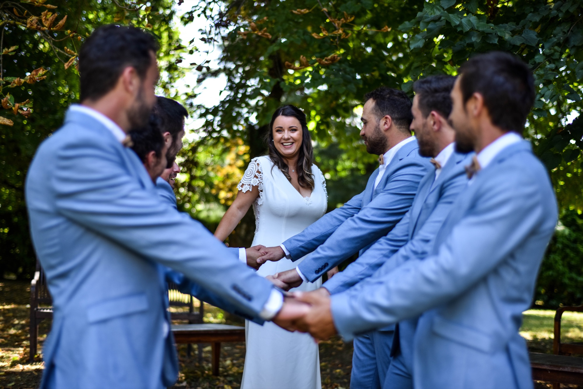 Mariée qui rit avec ses garçons d'honneur